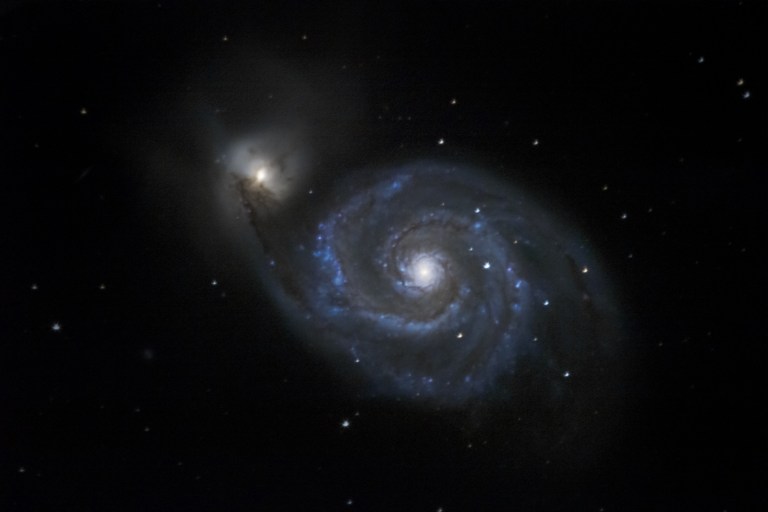 M51 - The Whirlpool Galaxy A face-on spiral galaxy currently undergoing a collision with its dwarf galaxy companion to the upper left.