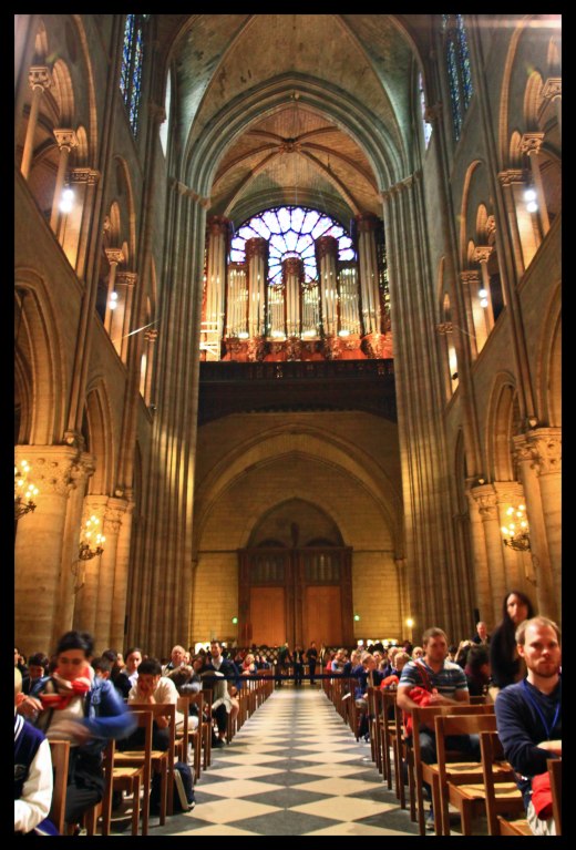 Looking toward the back of the cathedral, the largest organ in France (the "great organ") can be seen beneath the stained glass window.